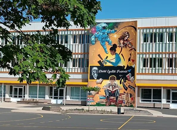 La grande fresque colorée « Liberté, Égalité, Fraternité » peinte sur la façade de l'école élémentaire